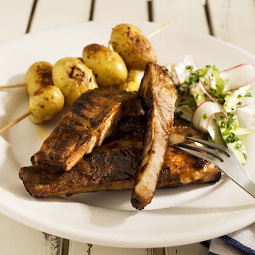 Spareribs med sallad på grön sparris och pepparrot. Saltbakade potatisar på spett.